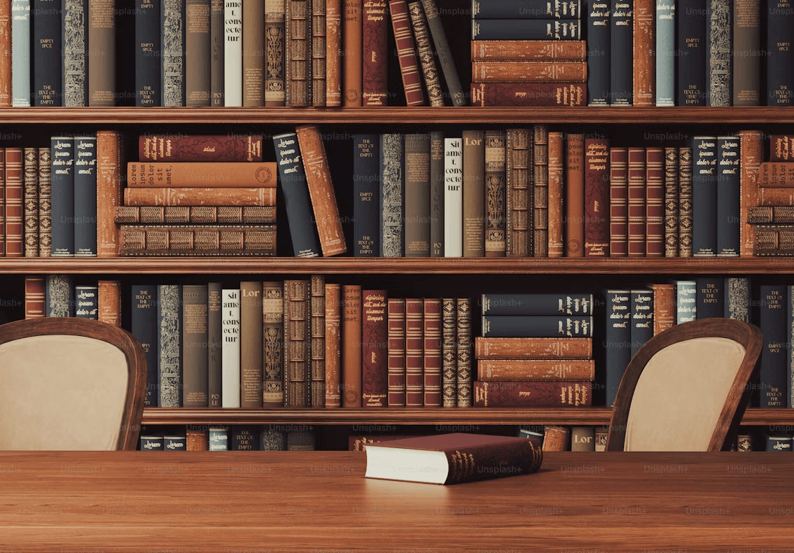 Traditional library study with a wooden desk, chairs, and shelves of leather-bound books